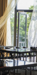 Tagungsraum C2 mit dem Fokus auf die wehenden Gardinen vor der bodentiefen Verglasung