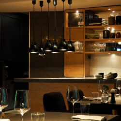 Aufnahme des Restaurants Genusswerkstatt mit dem Blick über die eingedeckten Tische hinweg zur Anrichtefläche