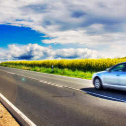 Auto fährt auf einer Landstraße über das Land