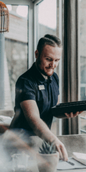 Unser Mitarbeiter Dennis Schmidt beim Eindecken eines Restaurant Tisches, er deckt gerade das Messer ein