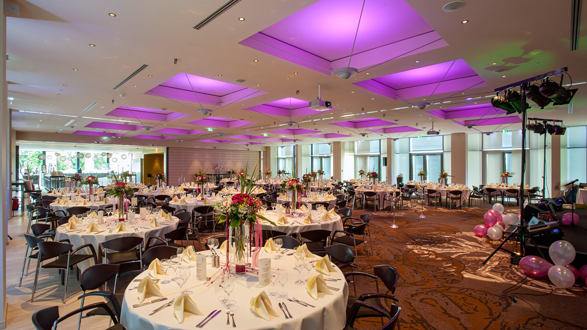 Veranstaltungsraum E1, E2 und E3 kombiniert aufgenommen aus der hinteren rechten Ecke, zu sehen eine klassische Bankett Bestuhlung an runden Tischen schön dekoriert und eingedeckt für eine große Hochzeit