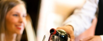 Waiter serving red wine