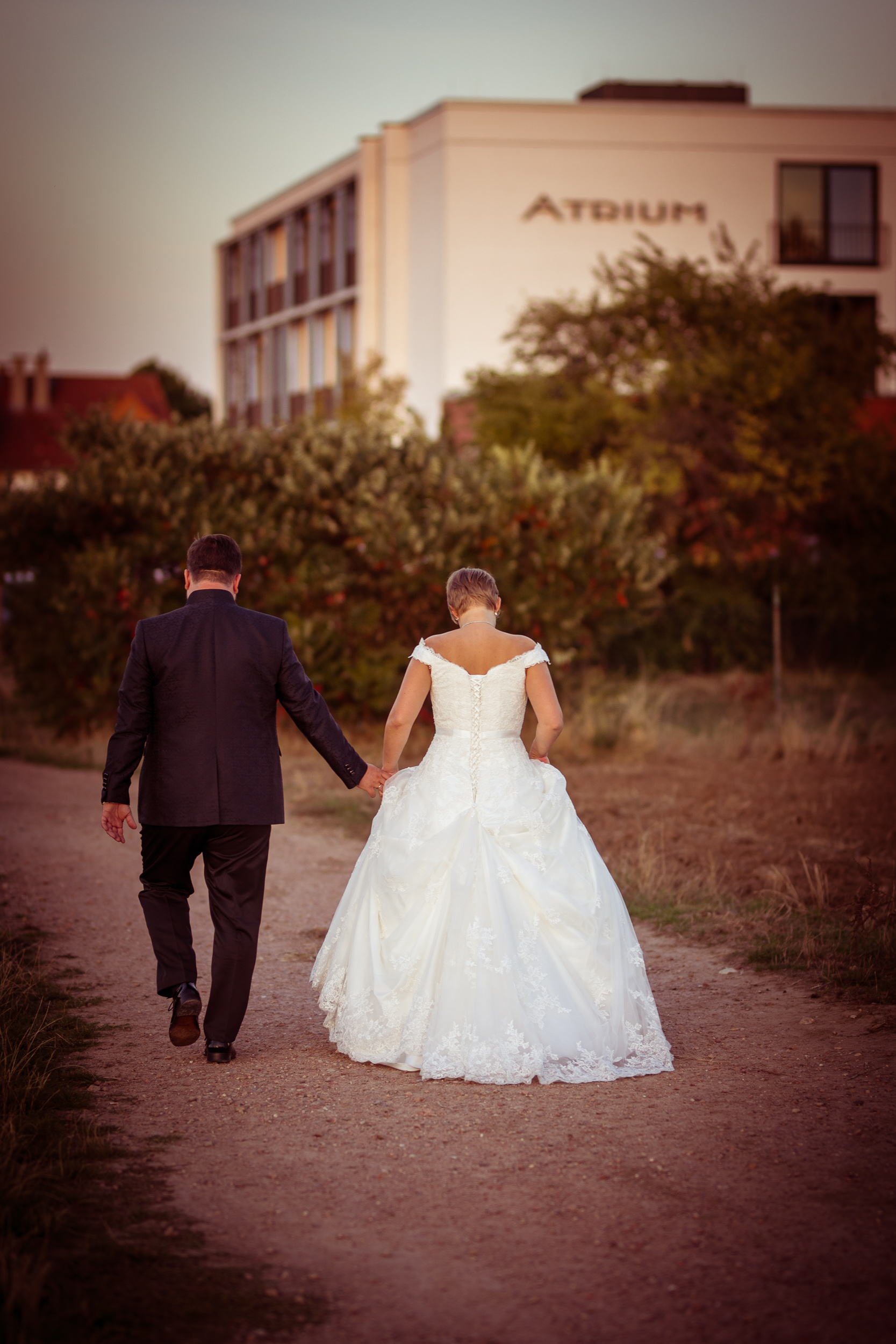 Hochzeitspaar auf Schotterweg vor Atrium Hotel Mainz